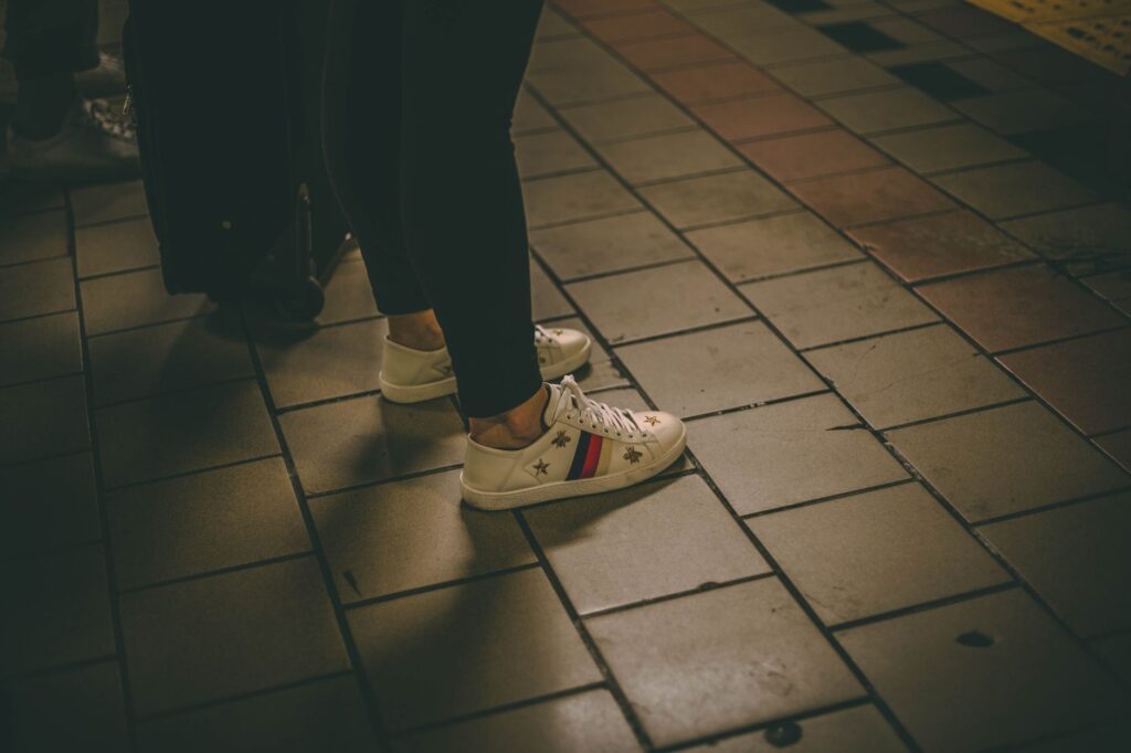 A woman in leggings, a longline cardigan, and sneakers
