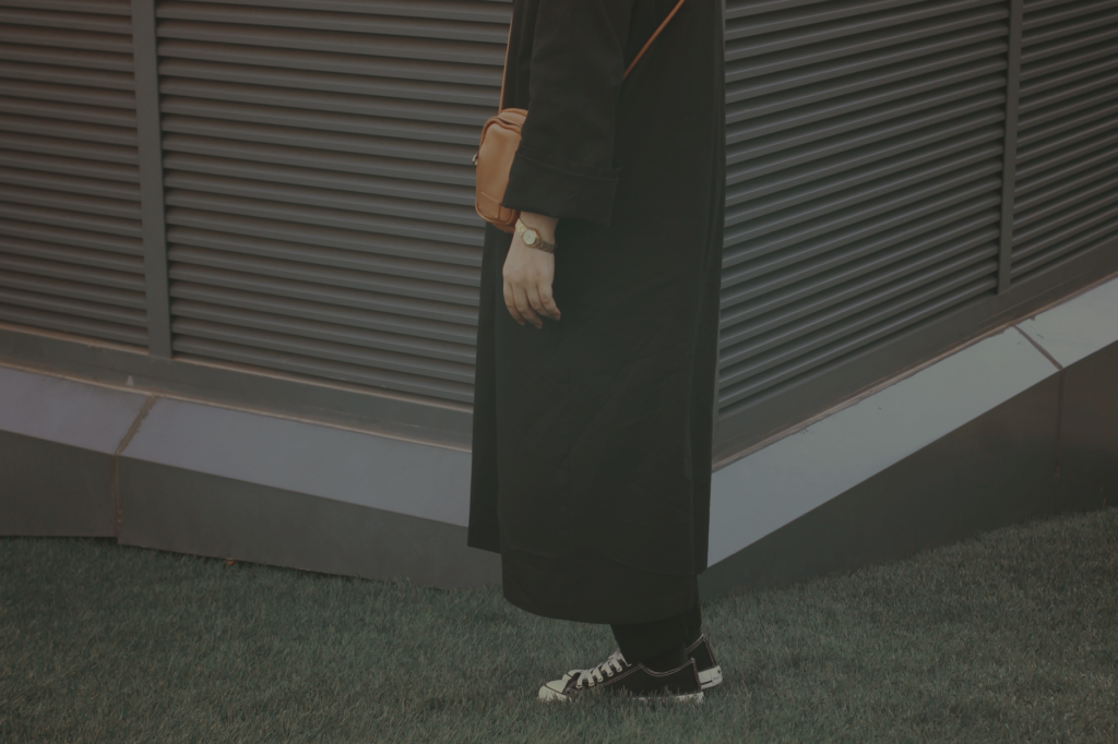 A woman wearing a neutral crossbody bag