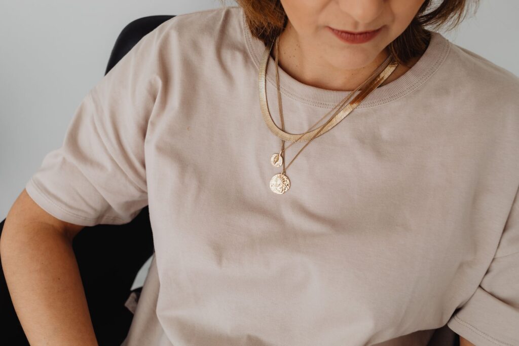 A woman wearing layered delicate necklaces