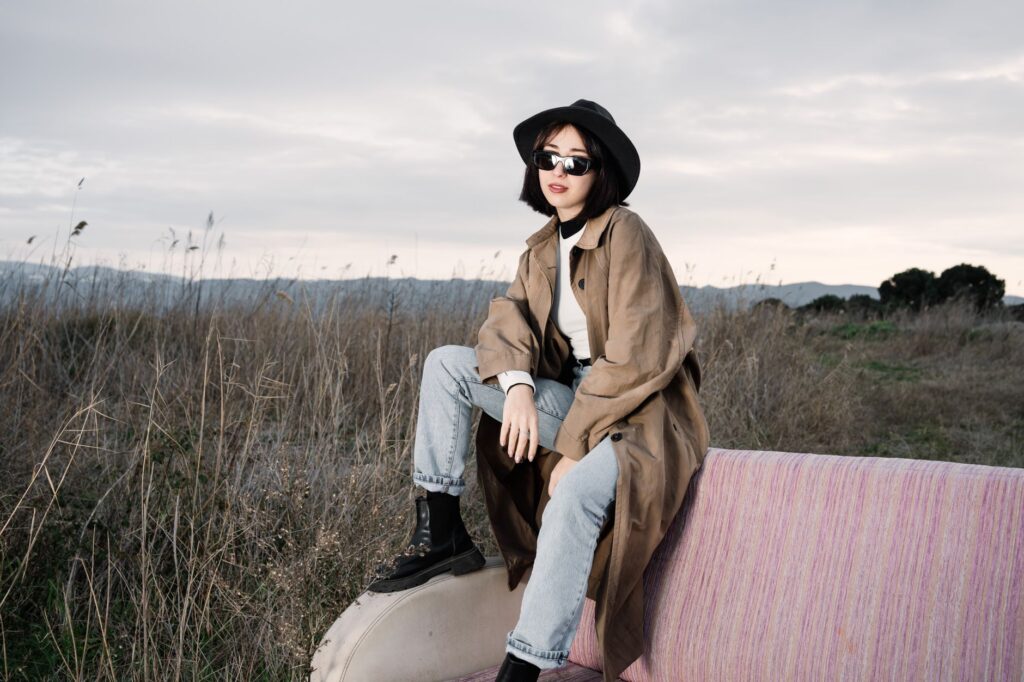 A woman wearing a trench over jeans and boots