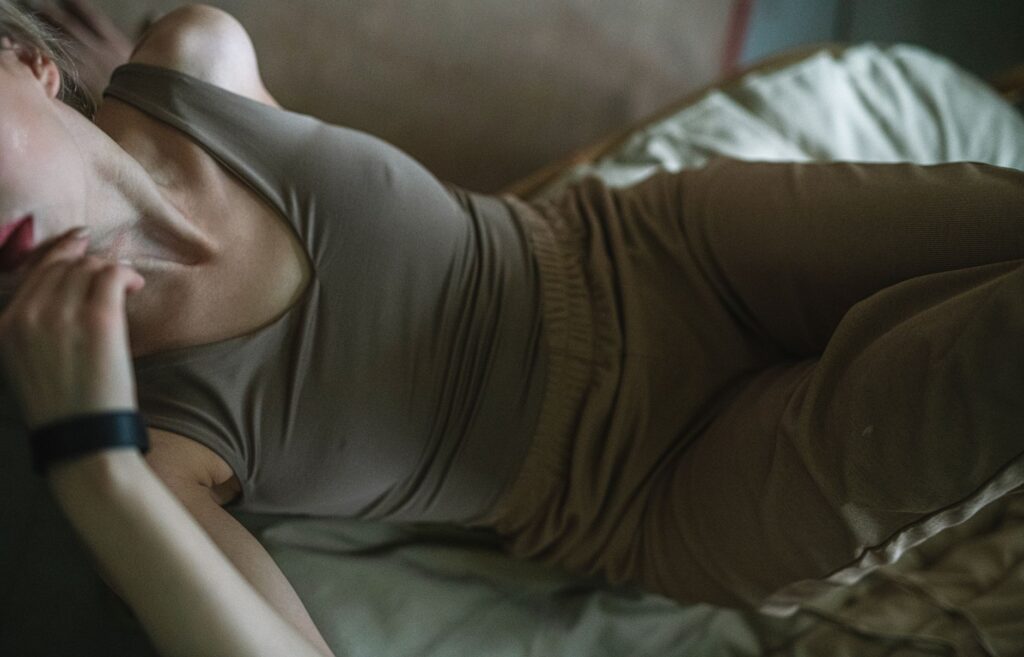 Woman lying down in casual fashion wear indoors, wearing a wristwatch.