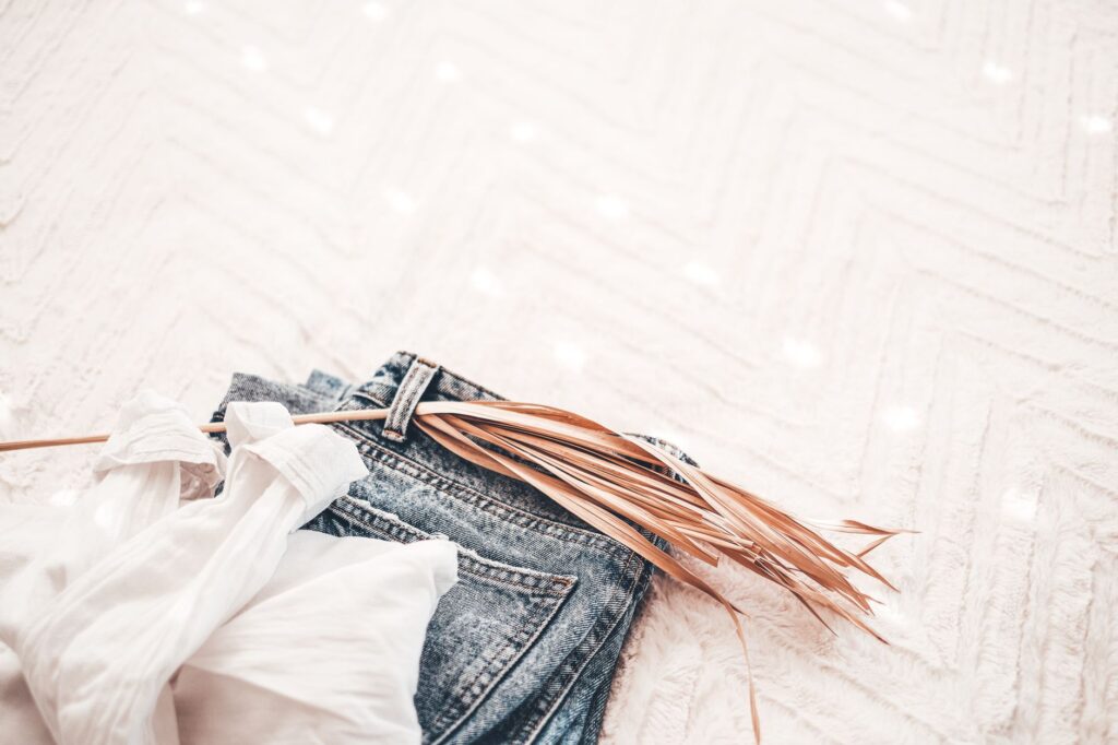 A flat lay of neutral fall clothing in camel, cream, and brown