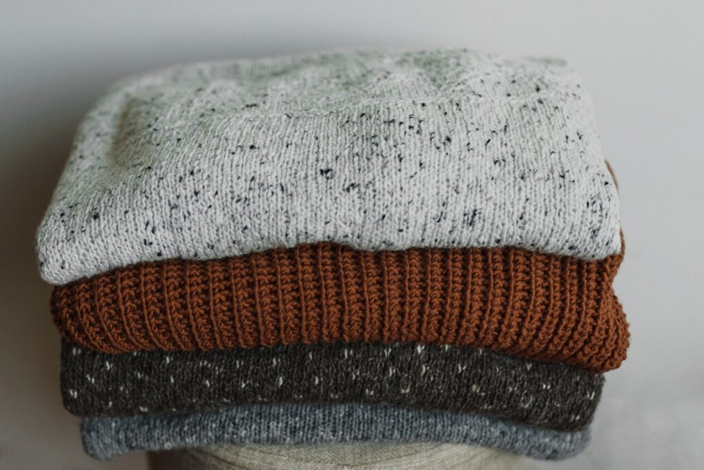 Neatly folded neutral tops and knitwear