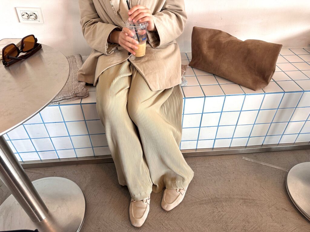 A woman in trousers, a knit, and loafers