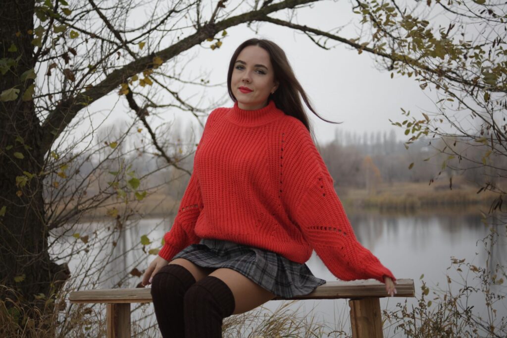 woman in knee high black leather boots with midi skirt and oversized sweater