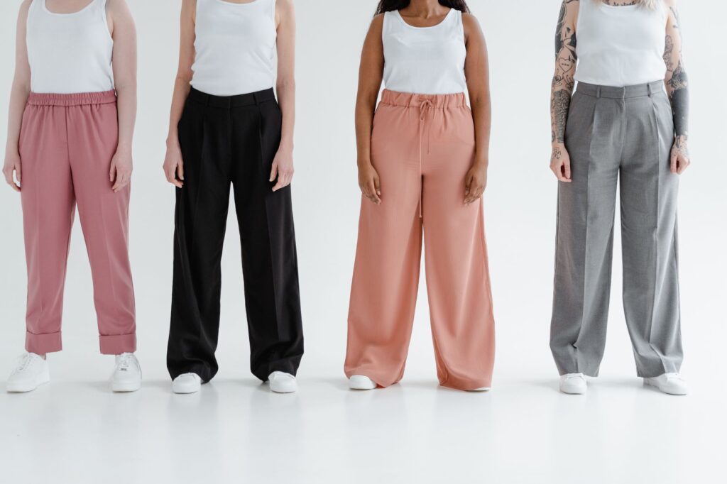 A woman in wide-leg trousers and a tucked top