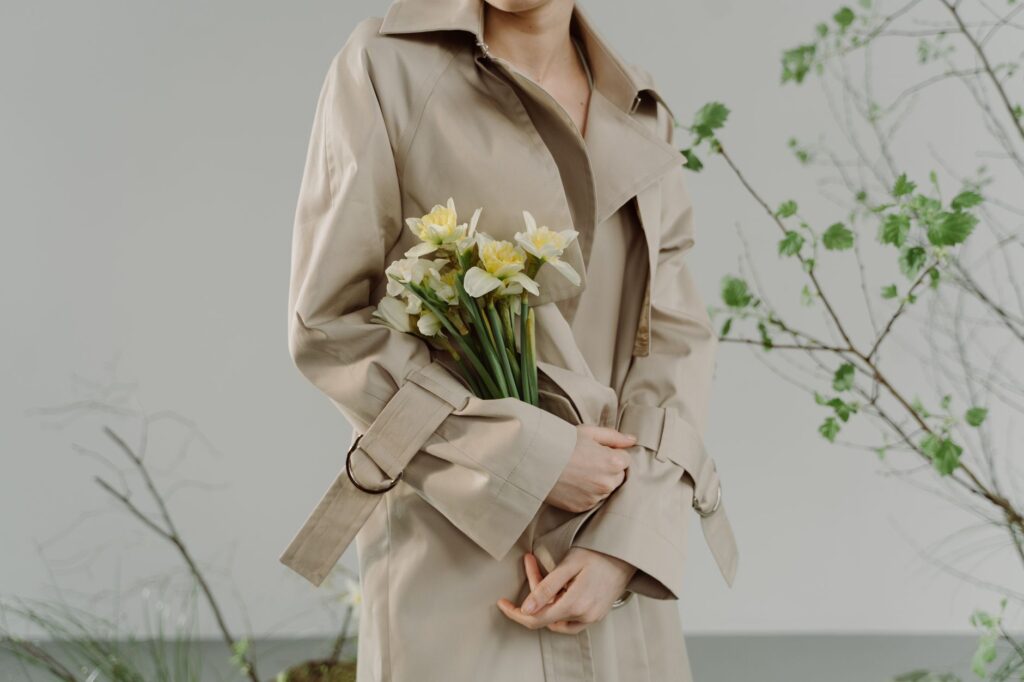 A woman in a light spring outfit with a trench coat