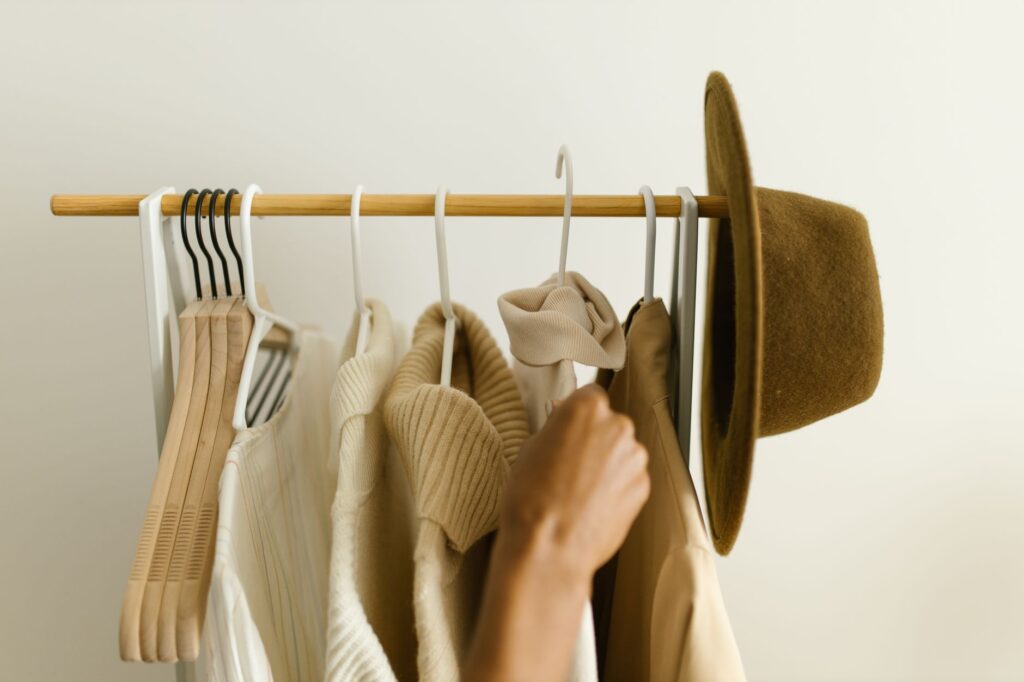 A rack of neutral wardrobe staples in cream, white, and navy