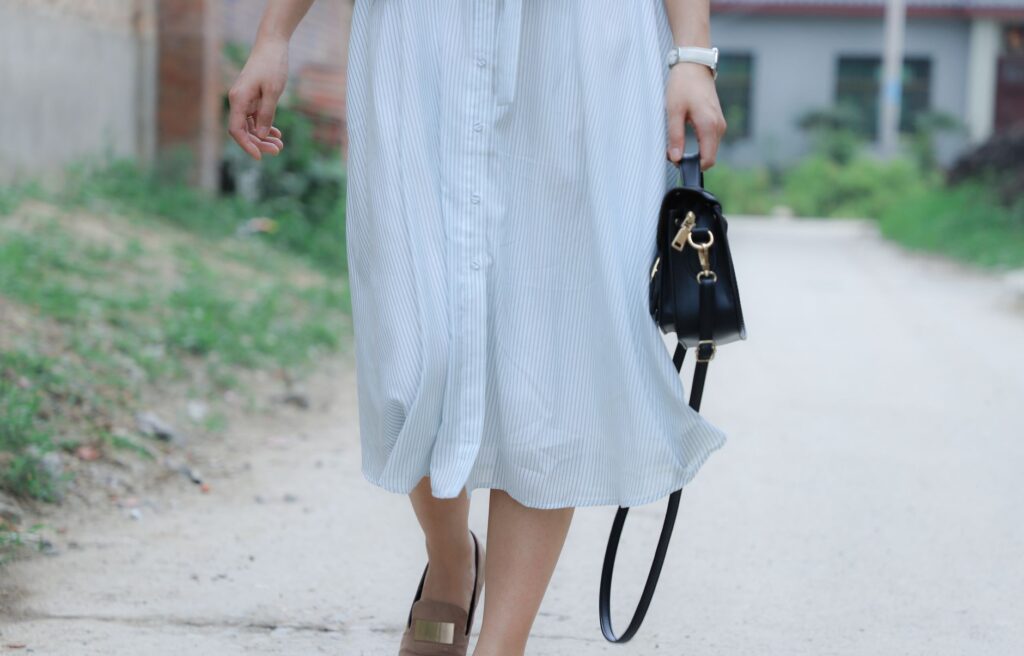 Woman wearing a midi dress with sneakers in a casual street style outfit