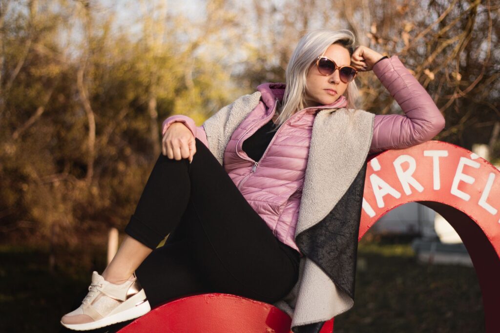 Woman wearing a long puffer jacket with leggings and sneakers