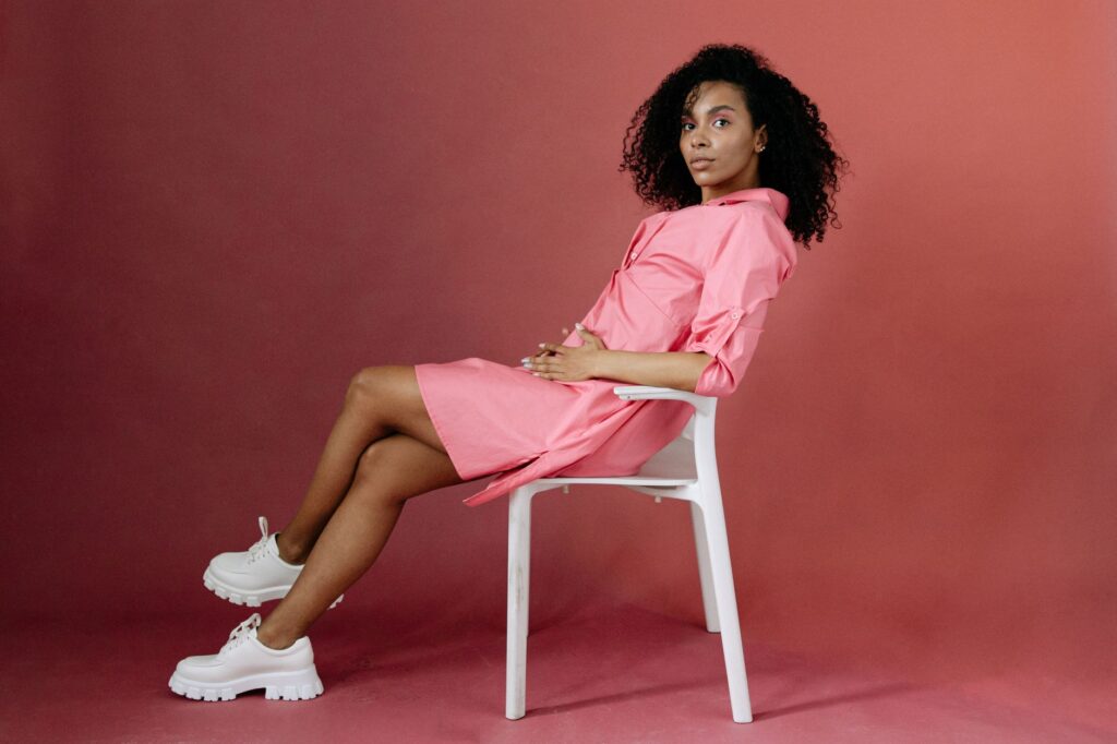 Woman wearing a belted shirt dress with sneakers on a city street