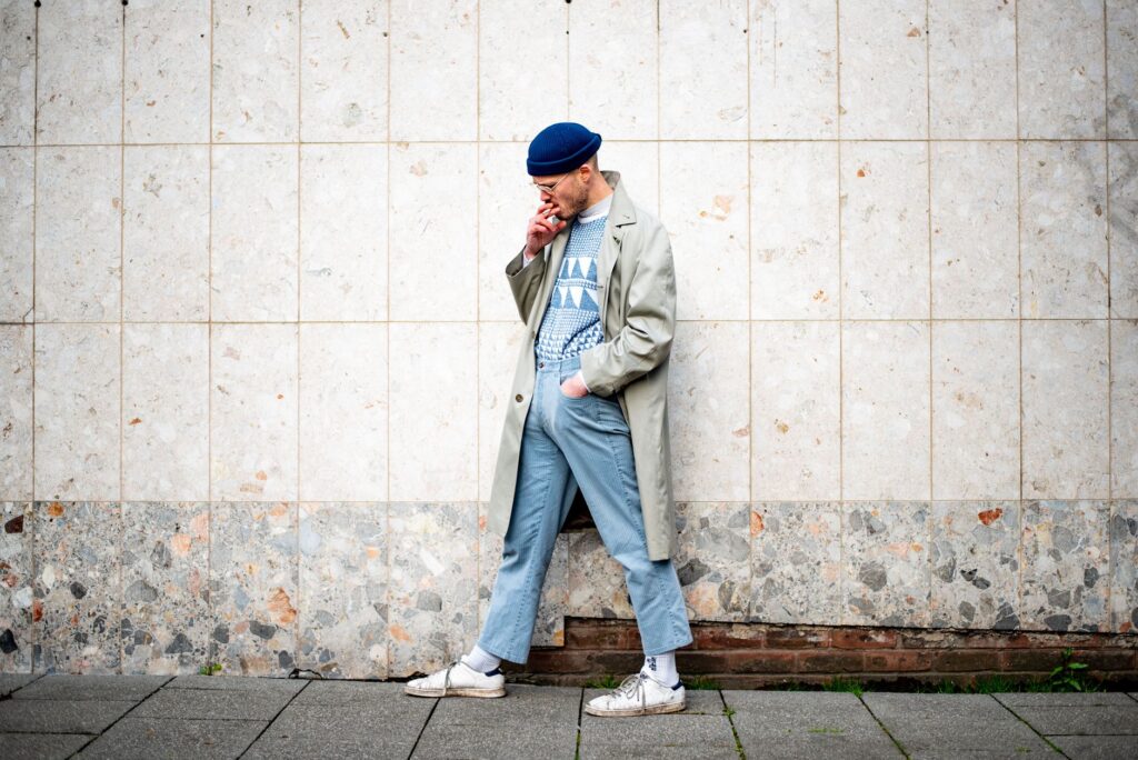 Casual outfit pairing a trench coat with jeans and white sneakers