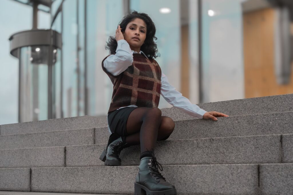 Sweater vest layered over a collared button-down shirt with jeans