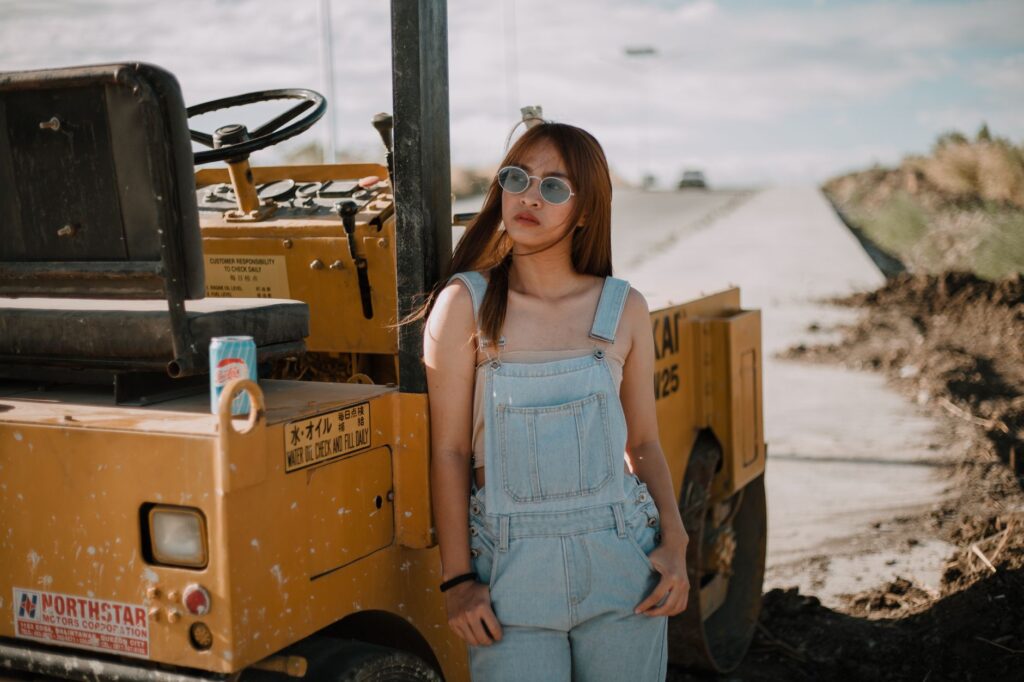 Woman styling denim overalls in a modern, polished outfit