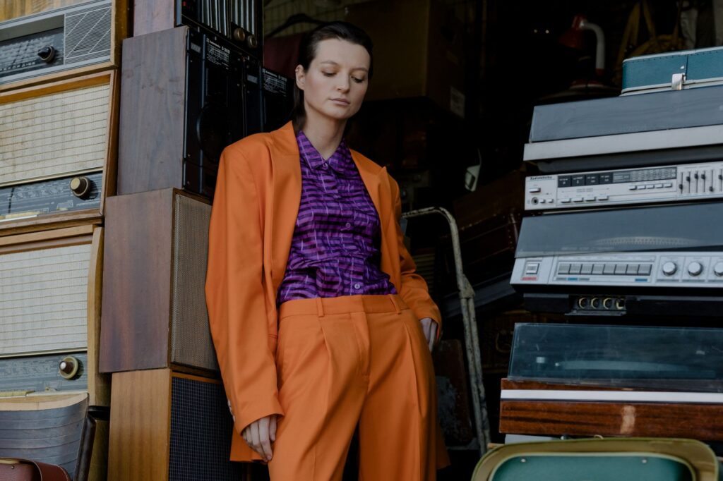 A stylish outfit built around a rich purple piece, styled with neutral accessories