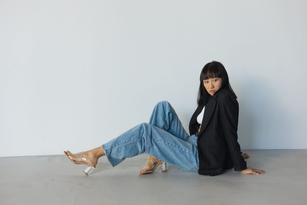 A woman styling wide-leg jeans with heels and a blazer