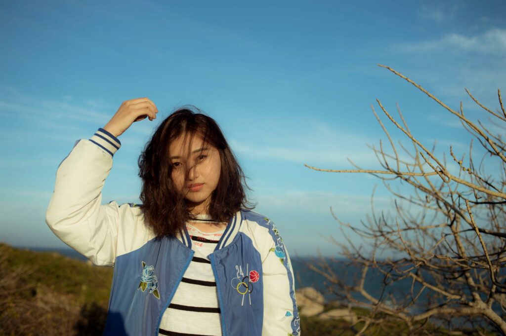 Bomber jacket layered over a slip dress for a casual-chic look