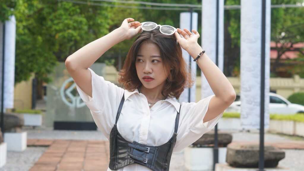 Woman wearing a corset top layered over a white button-down shirt