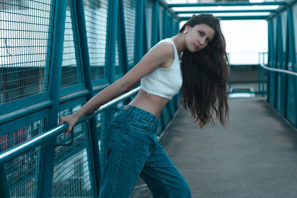 Woman wearing a fitted crop top with high-waisted jeans on a city street