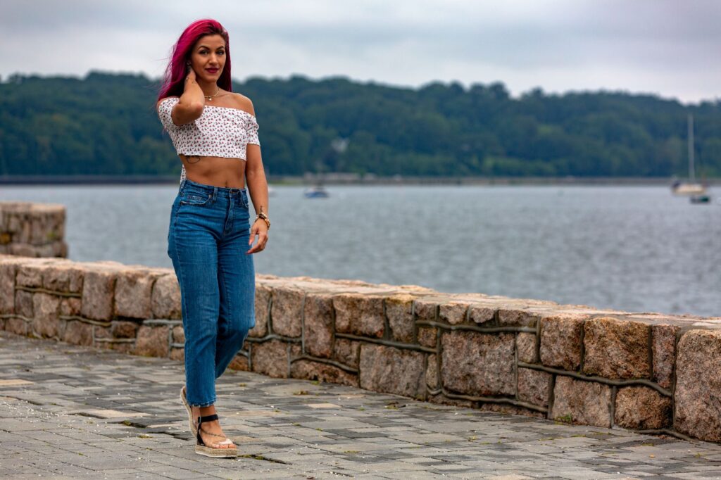 Woman wearing a fitted crop top tucked into high-waisted straight-leg jeans
