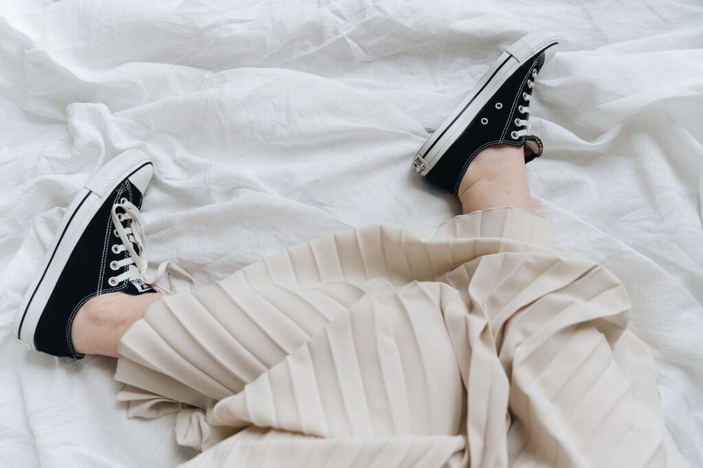 Pleated skirt styled casually with a t-shirt and white sneakers