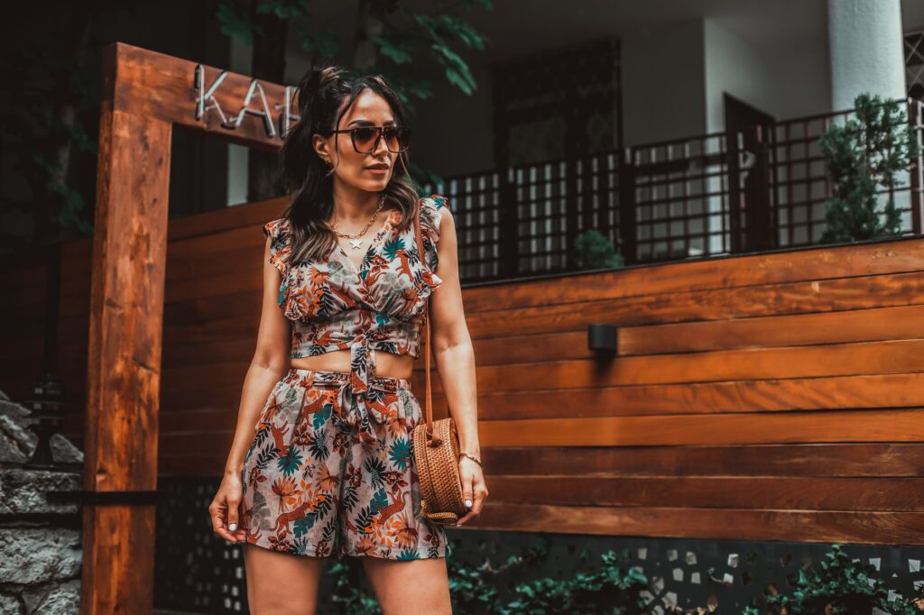 Woman wearing a romper with sandals on a sunny street