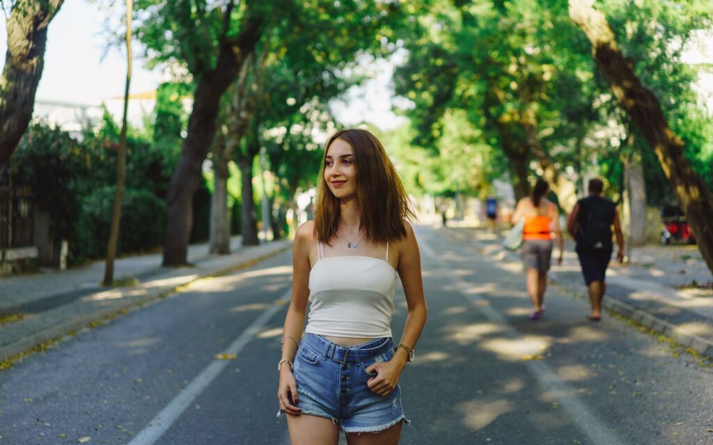Woman styling a white ribbed tank top with high-waisted jeans