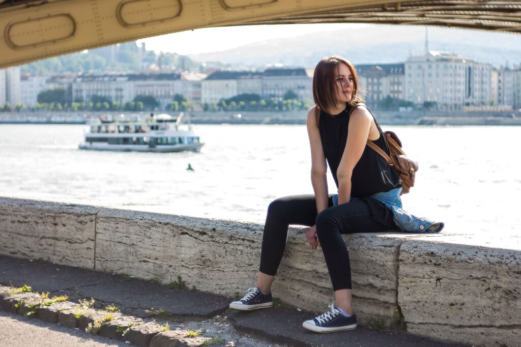 Fitted tank top layered under an oversized cardigan with wide-leg jeans
