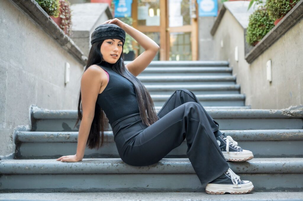 Stylish woman in black outfit posing outdoors on steps in Ciudad de México.